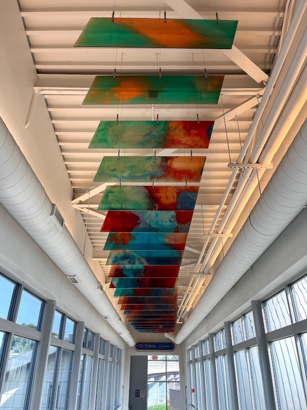 The suspension sculpture is inspired by the railroad track form representing the RTA station. The sculpture draws upon the significant role of rail transportation in American history. The colors of the sculpture are inspired by the changing landscapes and their seasonal variations. 