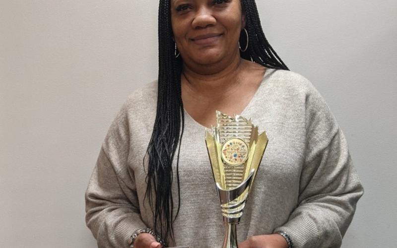 Teresa Muti pictured with her 2022 DEI Champion trophy and Oustanding Leadership plaque. 