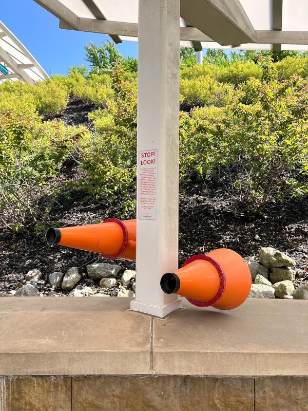 The colorful cones mounted on poles passed here are actually pieces of art. The cylinders are meant to resemble kaleidoscopes. Look into them and see either a scene from the industrial past of the neighborhood or one of the educational institutions present in the area. The words below the cylinders relate to the scene inside them. The red and orange cones illustrate industry while the blue and green relate to educaton. Take a minute and take a peek!