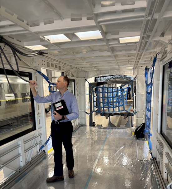 Donald Haradem (Vehicle Engineer) inspecting wiring during the first article inspection of the painted carshell.