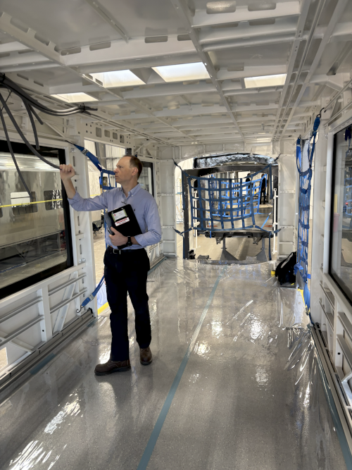 Donald Haradem (Vehicle Engineer) inspecting wiring during the first article inspection of the painted carshell.
